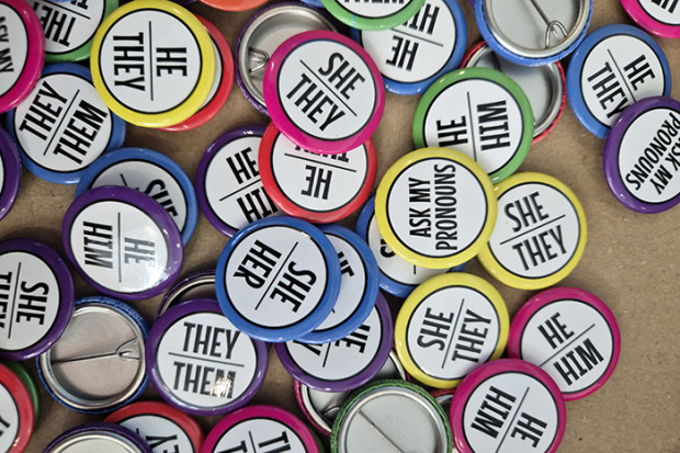Photo of different colored pins that have gender pronouns on them