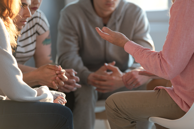 Photo of a group of people sitting in a circle talking