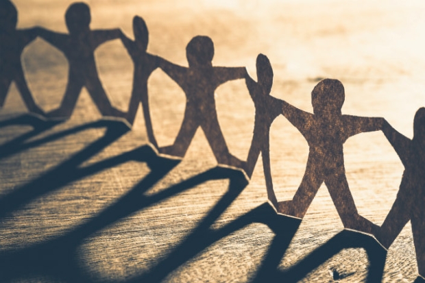 Paper chain of cutouts of tiny people holding hands