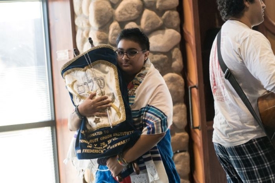 A person holding a Torah