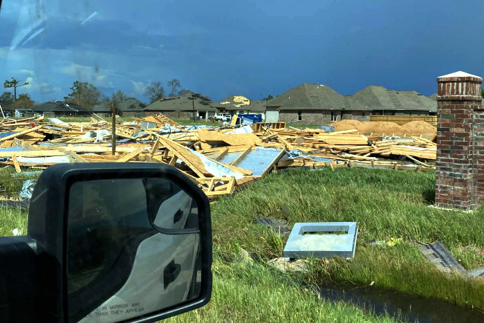 Houses wiped out by Hurricane Laura as photographed from the inside of a car with the side mirror visible