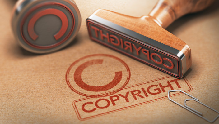 Two copyright stamps and their imprints in red ink on brown paper