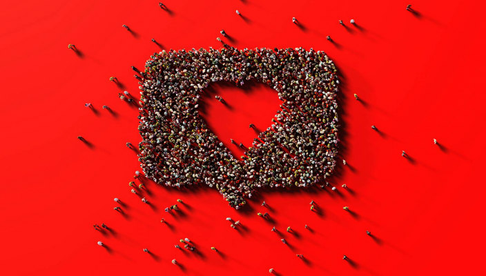 Human crowd forming a speech bubble with a heart shape inside representing an Instagram reaction icon