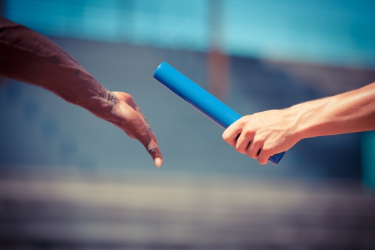 passing the baton during a relay race