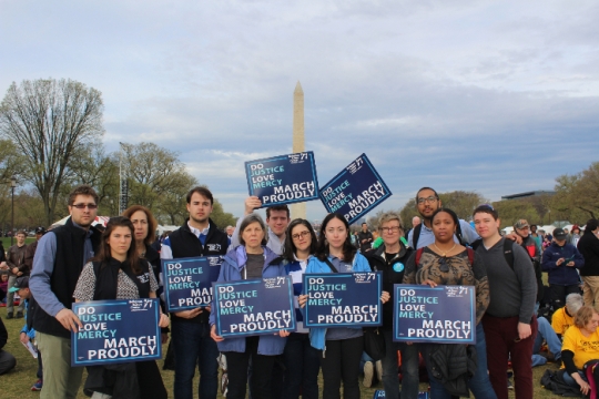 Group of people holding Jewish justice signs standing in front of the Washington Monument