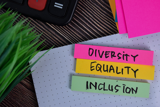 desk with three sticky notes that say diversity, equality and inclusion