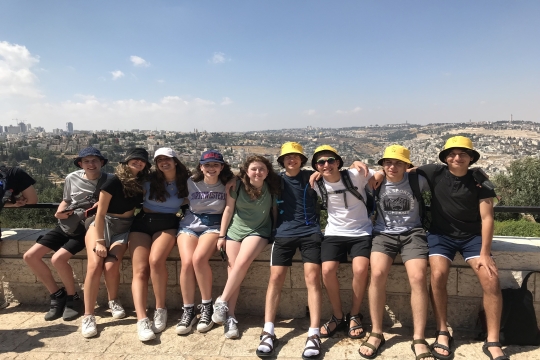 Group of teens sitting on a wall in Israel