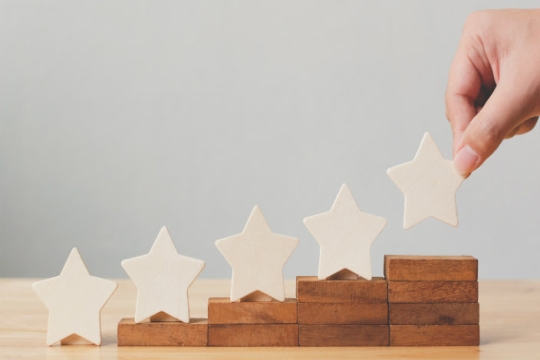 Hand adding a star to an ascending arrangement of stars