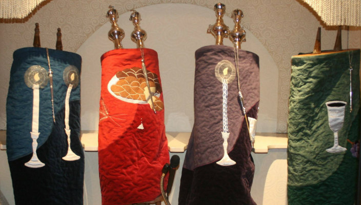 Four Torah scrolls sitting in an ark 